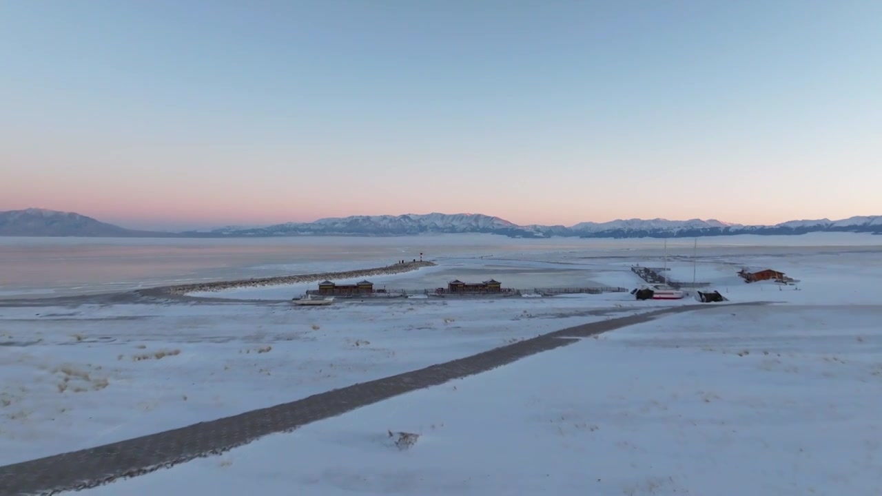 航拍冬季新疆赛里木湖雪山冰湖蓝冰日照金山夕阳雪山纹理视频下载