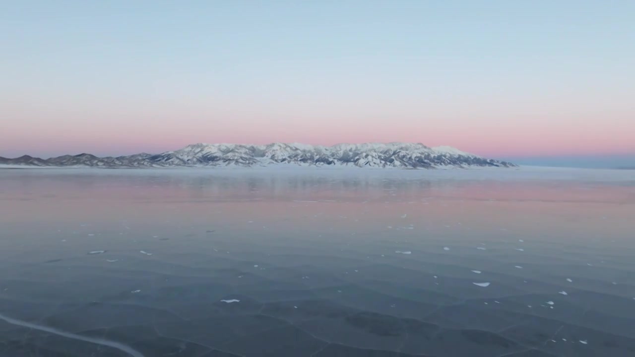 航拍冬季新疆赛里木湖雪山冰湖蓝冰日照金山夕阳雪山纹理视频下载