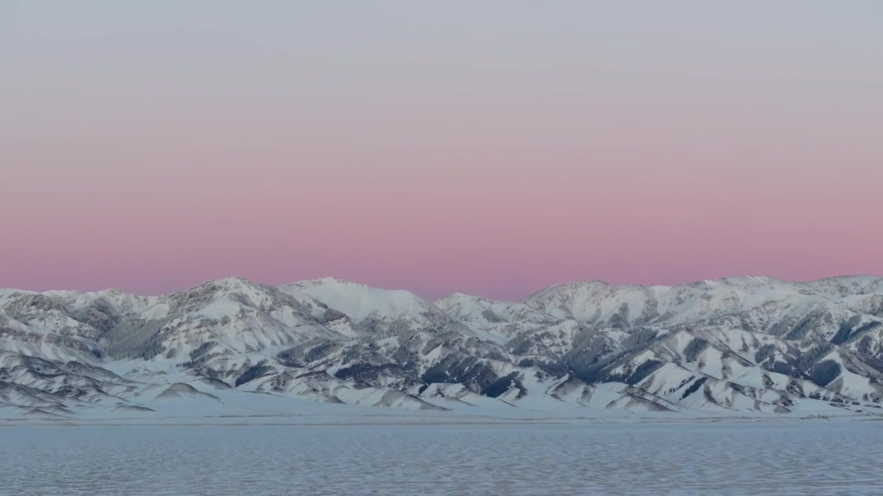 航拍冬季新疆赛里木湖雪山冰湖蓝冰日照金山夕阳雪山纹理视频下载