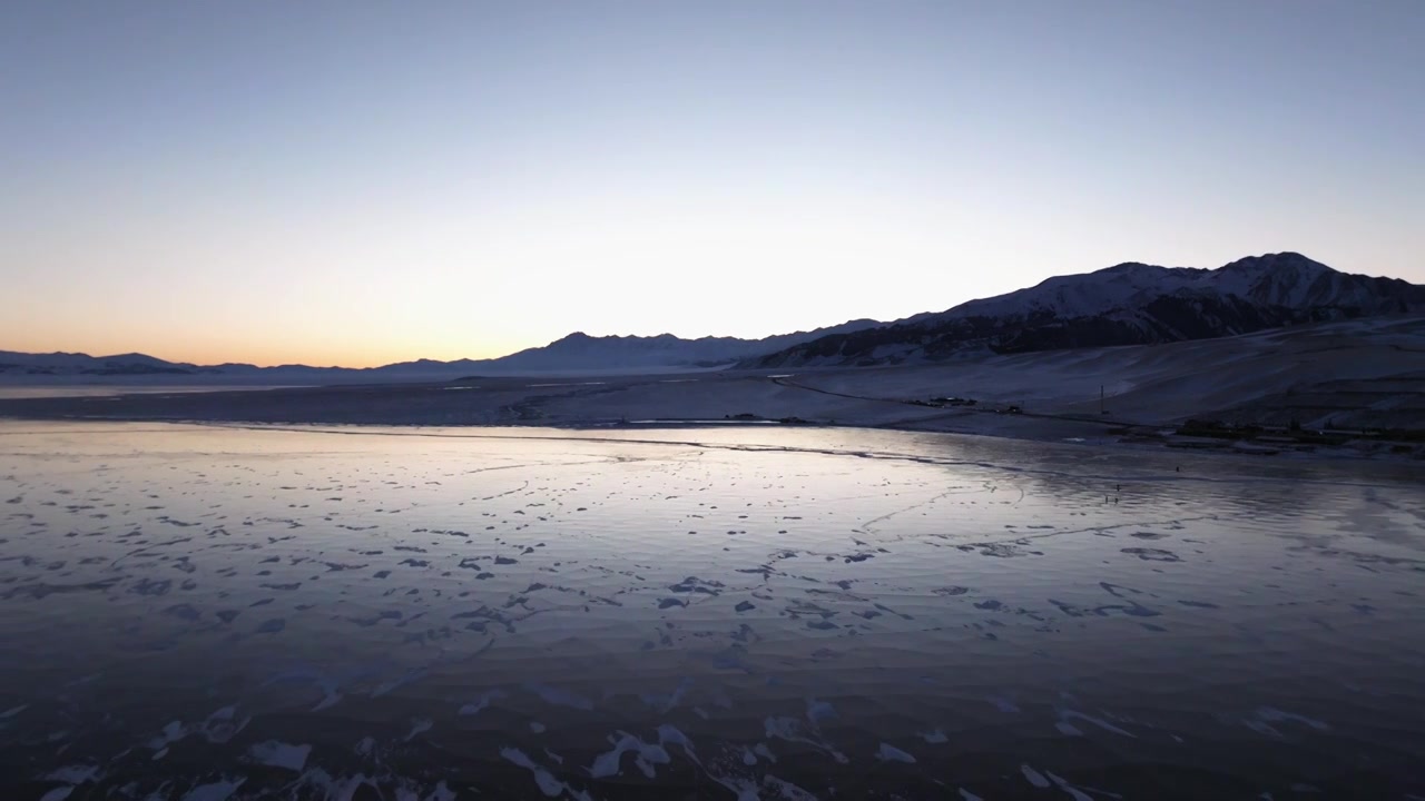 航拍冬季新疆赛里木湖雪山冰湖蓝冰日照金山夕阳雪山纹理视频下载