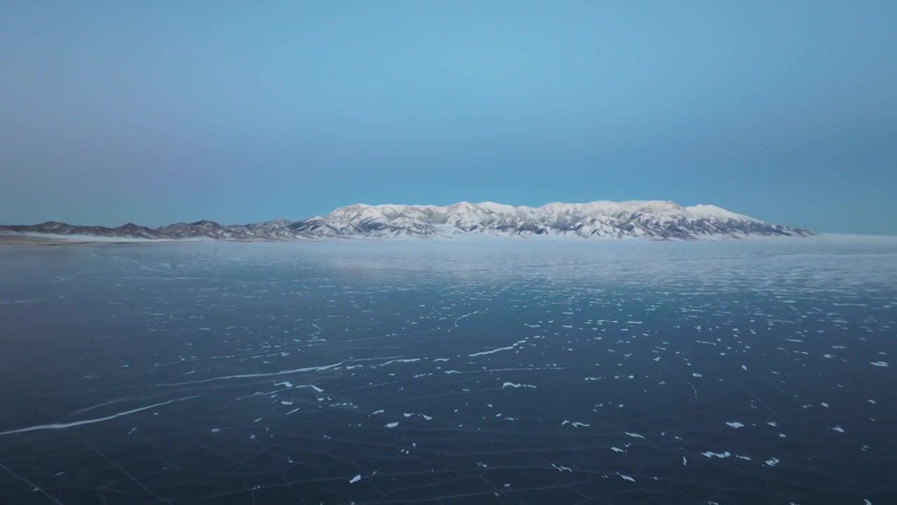 航拍冬季新疆赛里木湖雪山冰湖蓝冰日照金山夕阳雪山纹理视频素材