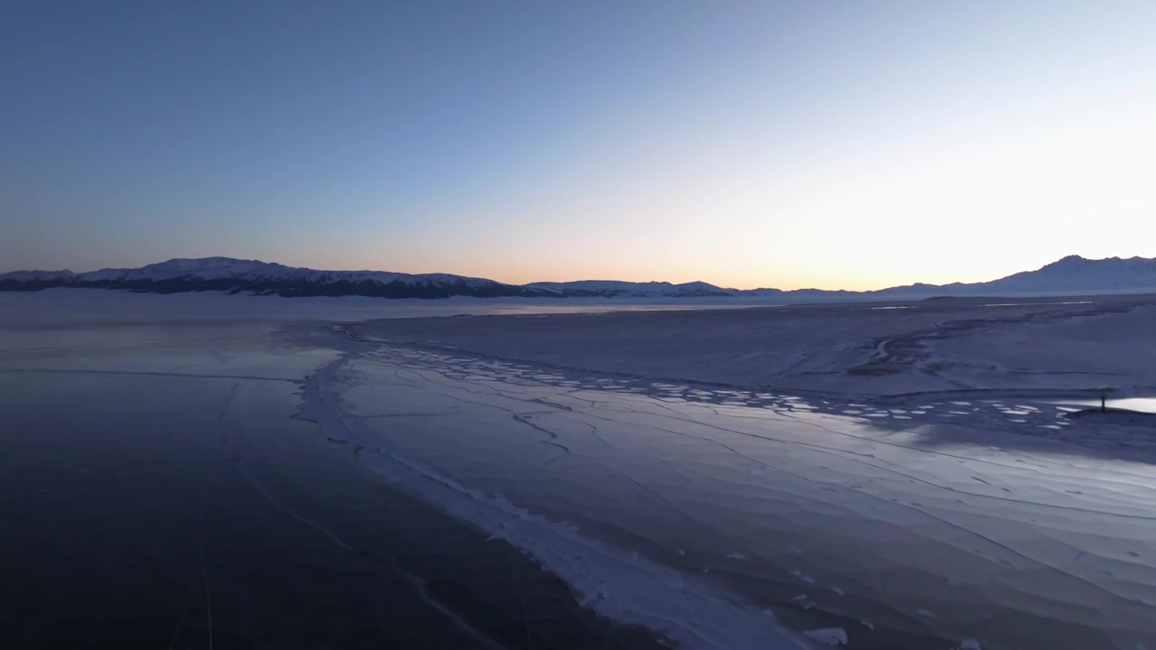 航拍冬季新疆赛里木湖雪山冰湖蓝冰日照金山夕阳雪山纹理视频下载