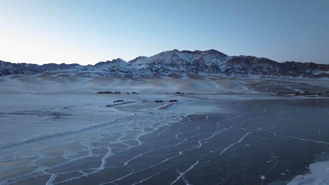 航拍冬季新疆赛里木湖雪山冰湖蓝冰日照金山夕阳雪山纹理视频下载