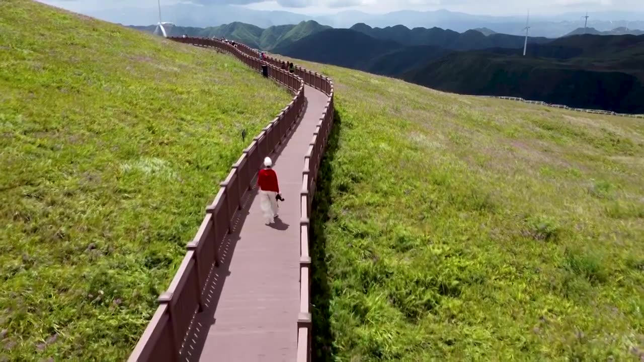 航拍一个旅游者走在贵州毕节韭菜坪的栈道上视频素材