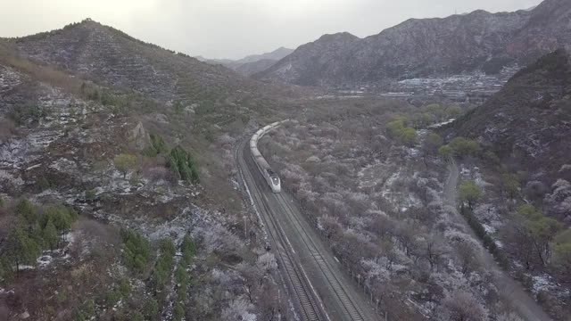 航拍居庸关长城雪后花海和谐号列车视频素材