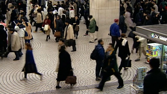 上下班高峰期穿过新宿站的通勤者/走下楼梯的通勤者/日本东京视频素材