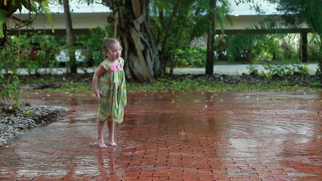 WS PAN Girl(2-3)在雨中跳舞，在水坑中溅水/拉米，美国新墨西哥州视频素材