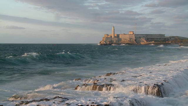 在古巴哈瓦那，海浪拍打着海岸与El Morro城堡视频素材