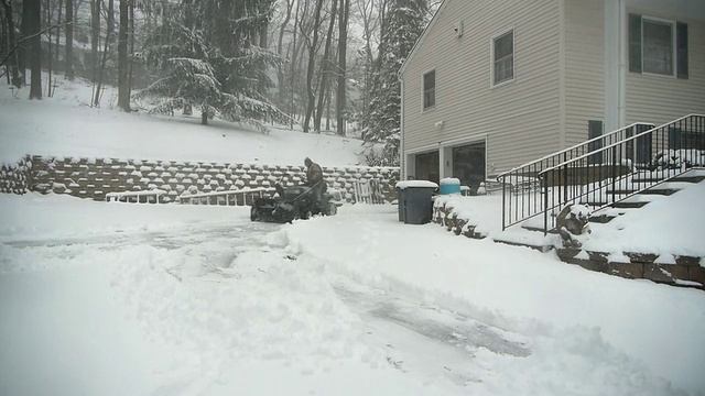 WS T/L人驾驶拖拉机除雪机，清除车道上的雪在暴风雪/莫里斯敦，新泽西州，美国视频素材