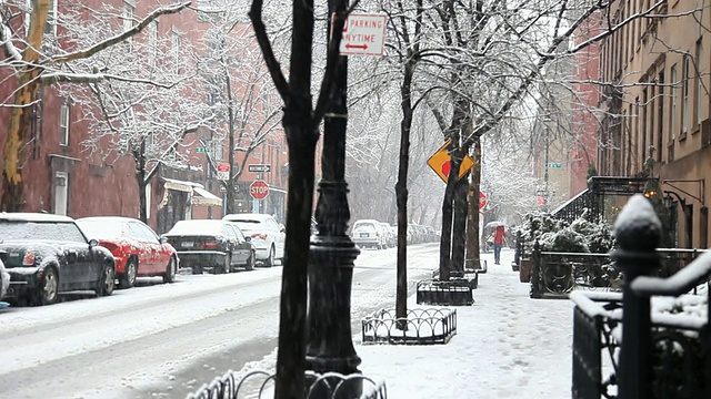 WS后视图的女人与伞走下格林尼治村街道在雪/纽约市，纽约，美国视频素材