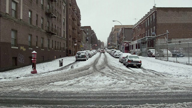 美国纽约州布朗克斯区/纽约市积雪覆盖的十字路口上的行人和车辆视频素材