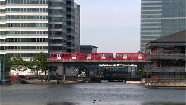 港区轻轨(DLR)横跨泰晤士河桥在伦敦港区/英国伦敦视频素材