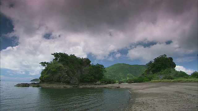 T/L WS云在科莫多岛/科莫多国家公园的海滩和绿色山丘上移动，东努沙登加拉，印度尼西亚视频素材