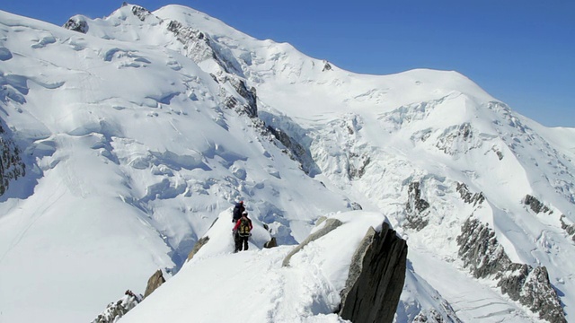 WS登山者在Aiguille du Midi与勃朗峰的顶峰背景/夏蒙尼，高级萨瓦，法国视频素材