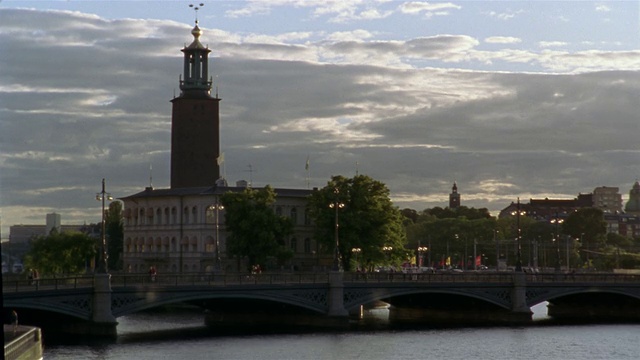 行人在Stadshusbron大桥上行走，背景为斯德哥尔摩市政厅(Stadshuset) /瑞典斯德哥尔摩视频素材