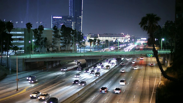 公路上的交通和摩天大楼照亮了夜晚/美国加州洛杉矶视频素材