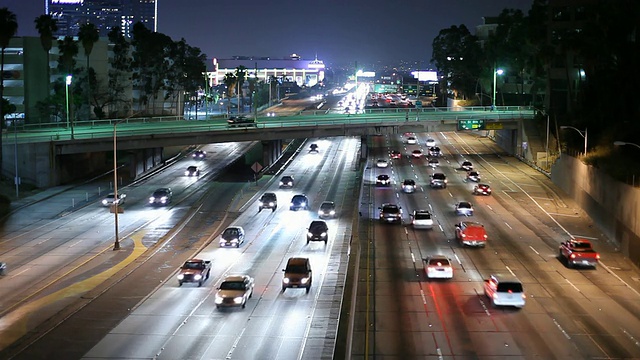 美国加州洛杉矶高速公路上的交通和摩天大楼夜间灯火通明视频素材