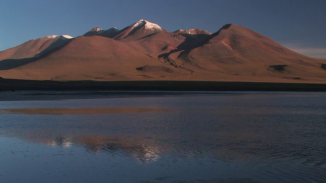 在玻利维亚奥鲁罗的popoo湖上，安第斯山脉的山峰上覆盖着白雪，天空湛蓝视频素材