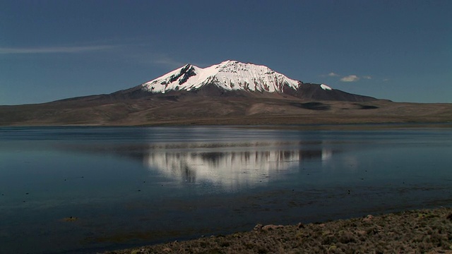 在智利的拉戈春加拉(Lago Chungara) /塔拉帕卡(Tarapaca)，奎西奎西尼(Cerro de Quisiquisini)的倒影在平静的湖水中视频素材