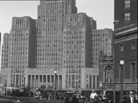 1938年7月B/W PAN TU街景，停在大型建筑前的汽车/伊利诺伊州芝加哥视频素材