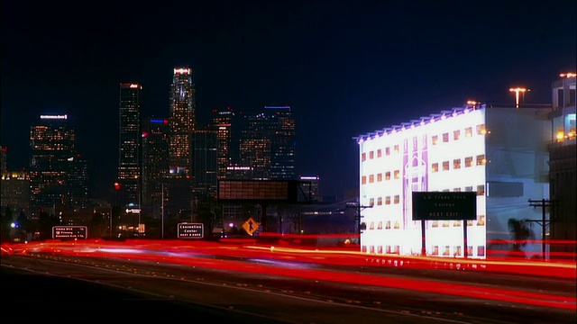 时间推移广角镜头在海港高速公路上的交通与市中心天际线的背景/晚上/洛杉矶，加利福尼亚视频素材