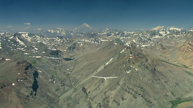 2010年，空中滑翔机在多岩石的雪山上空飞行/智利圣地亚哥，大圣地亚哥，智利视频素材