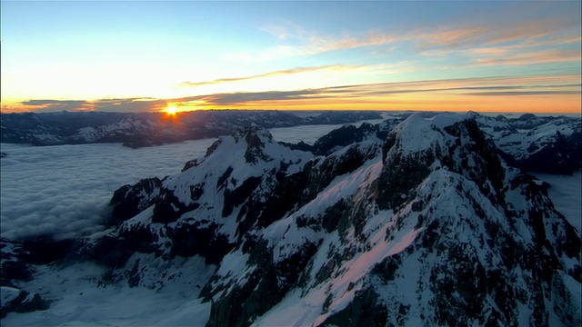 低空俯瞰，夕阳下白雪覆盖的图托科山，新西兰峡湾国家公园视频素材