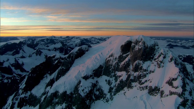 低空俯瞰，夕阳下白雪覆盖的图托科山，新西兰峡湾国家公园视频素材