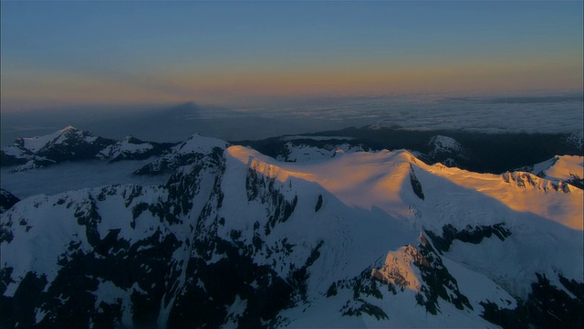 低空俯瞰，夕阳下白雪覆盖的图托科山，新西兰峡湾国家公园视频素材