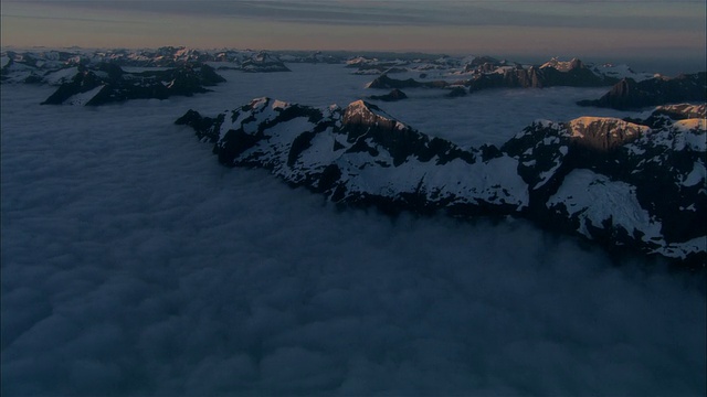 低空俯瞰，夕阳下白雪覆盖的图托科山，新西兰峡湾国家公园视频素材