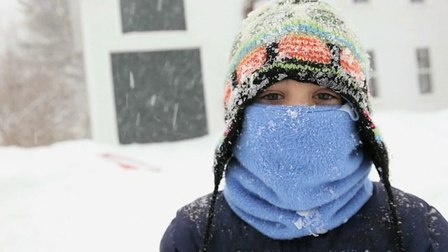 在暴风雪期间，CU男孩穿着暖和的衣服/美国缅因州雅茅斯视频素材