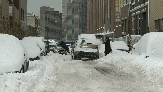 美国纽约，人们在清理被雪覆盖的汽车视频素材