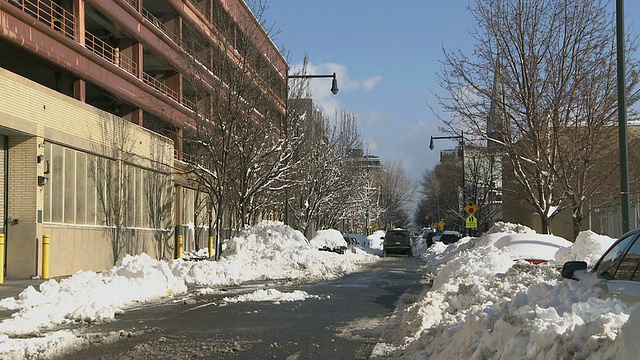 WS汽车在有雪堆的街道上行驶/纽约，纽约，美国视频素材