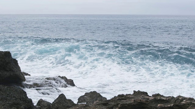 海浪形成并撞击岩石的锁定镜头视频素材