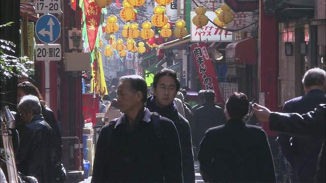 日本神奈川县横滨，行人走过拥挤狭窄的街道，经过当地的商店视频素材