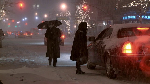 一个女人试图在雪地里打一辆出租车。视频素材