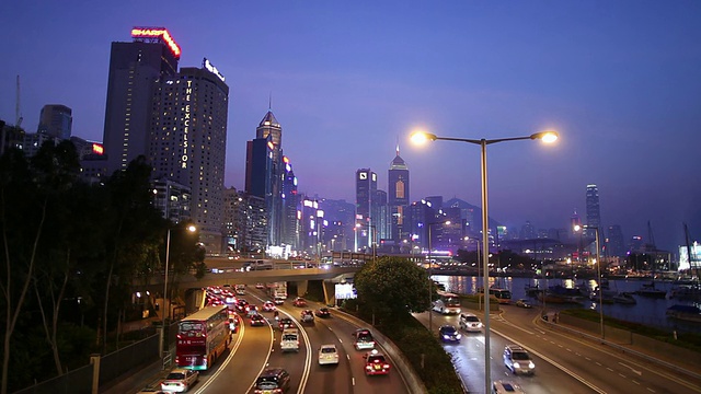 WS道路上的交通，背景是市中心的天际线，黄昏/中国香港视频素材