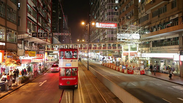 中国香港，晚上有轨电车在市中心街道上行驶视频素材