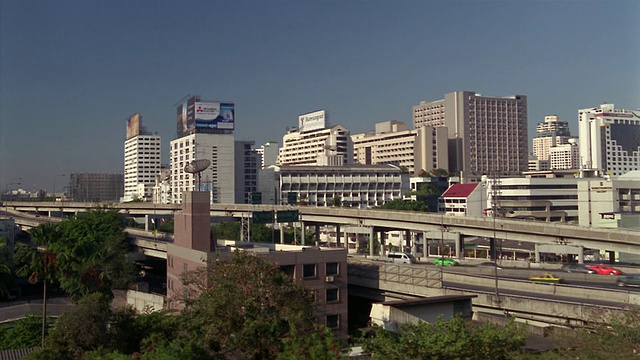 泰国曼谷素坤逸区高速公路上的交通，背景中的城市天际线视频素材