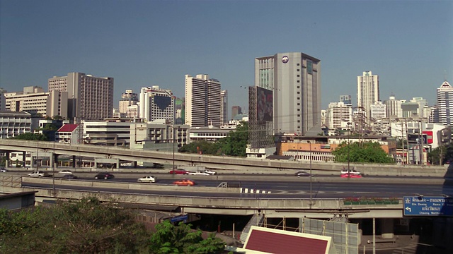 泰国曼谷素坤逸区高速公路上的交通，背景中的城市天际线视频素材