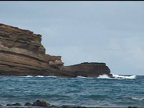 海浪冲击着哈瑙马湾的岩石海岸。视频素材