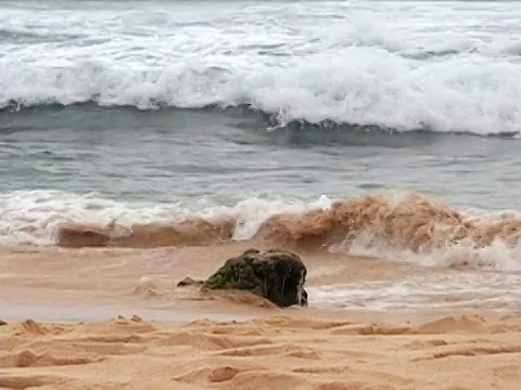 海浪冲到海滩上的岩石上视频下载