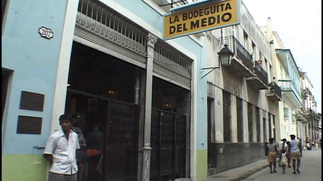 宽镜头人们走过La Bodeguita del Medio/古巴哈瓦那视频素材