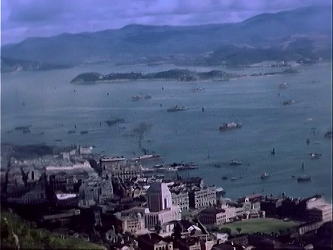 1939高角度宽镜头拍摄海港中大小船只，背景为山脉/香港视频素材