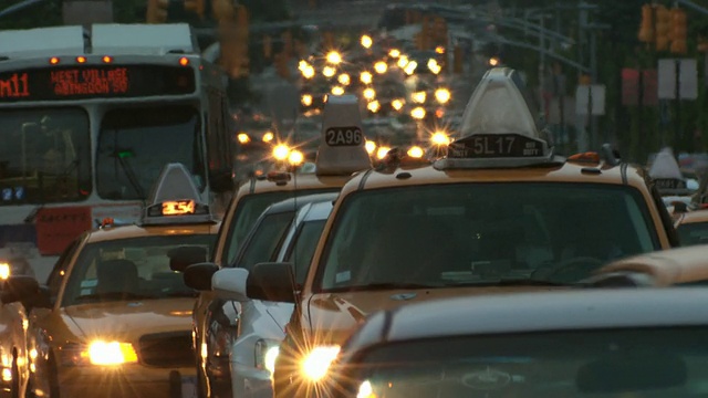 傍晚时分，街道上挤满了汽车、出租车和公共汽车。灯光在夏天的炎热中闪烁视频素材