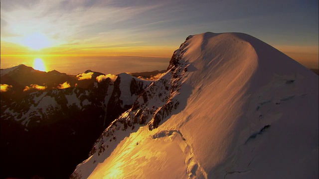 低空俯瞰，初升的阳光下白雪覆盖的图托科山，新西兰峡湾国家公园视频素材