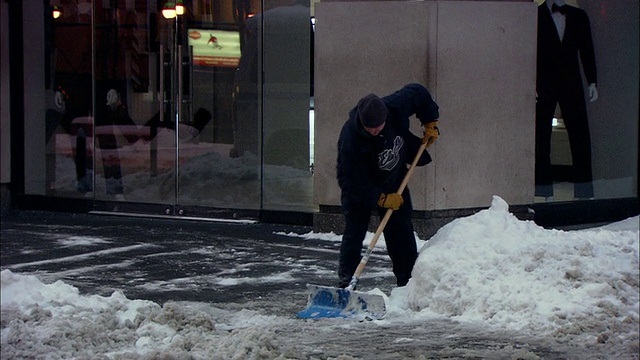 美国纽约，潘佐曼女士正在铲雪，清理商店前的人行道和步行上班的人们视频素材