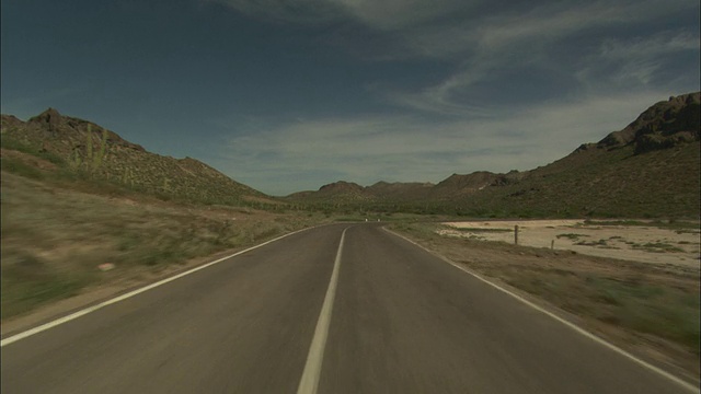 POV，行驶在铺设的，弯曲的两车道道路上，穿越沙漠景观，下加利福尼亚，墨西哥视频素材