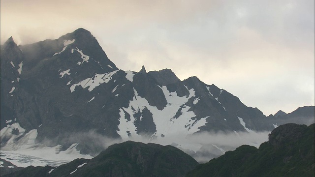 美国阿拉斯加州基奈峡湾国家公园，白雪覆盖的岩石山峰山峰上有薄雾视频素材