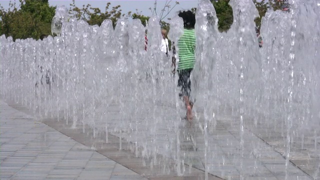 夏天，孩子们在喷泉间玩耍。视频素材